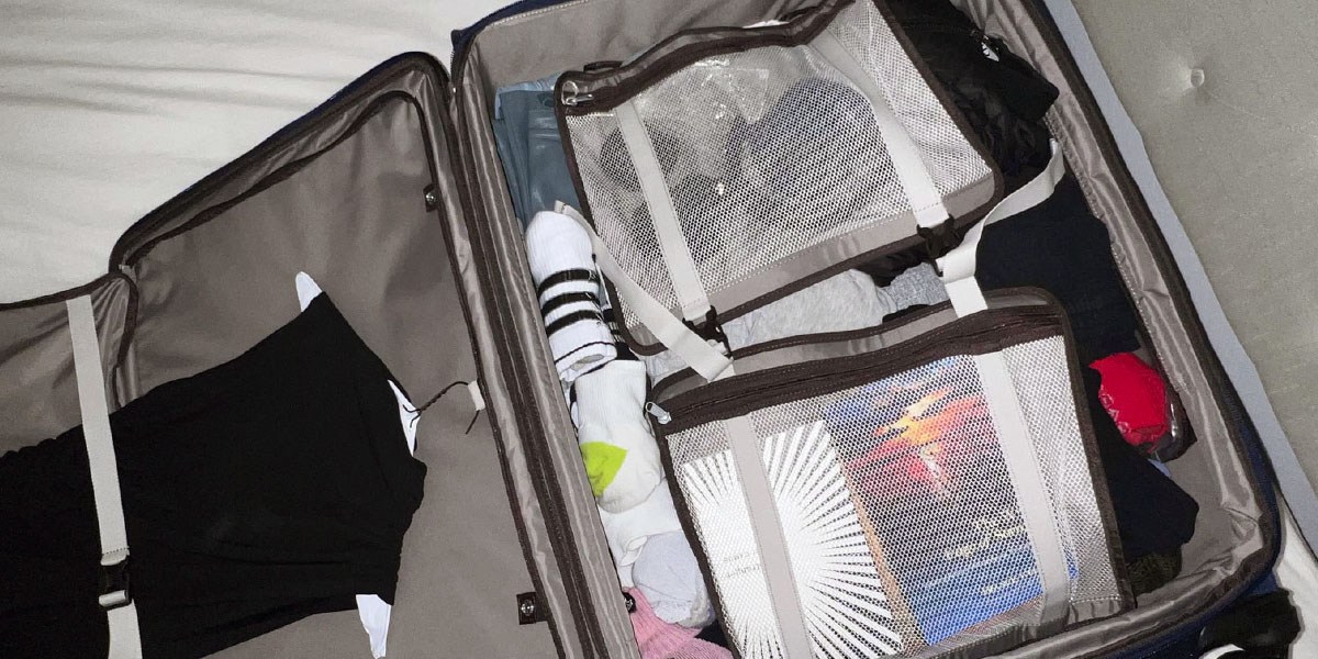 Travelpro Platinum Elite Softside Expandable Checked Luggage open on bed Travelpro Platinum Elite Softside Expandable Checked Luggage open on bed