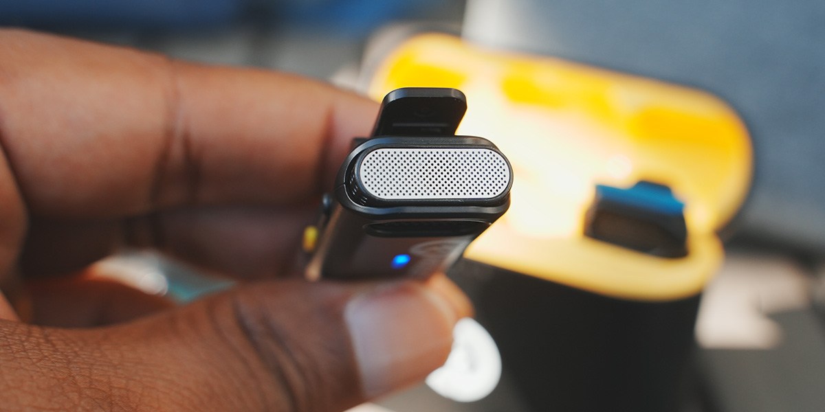 Hand holding lavalier microphone with top view showing