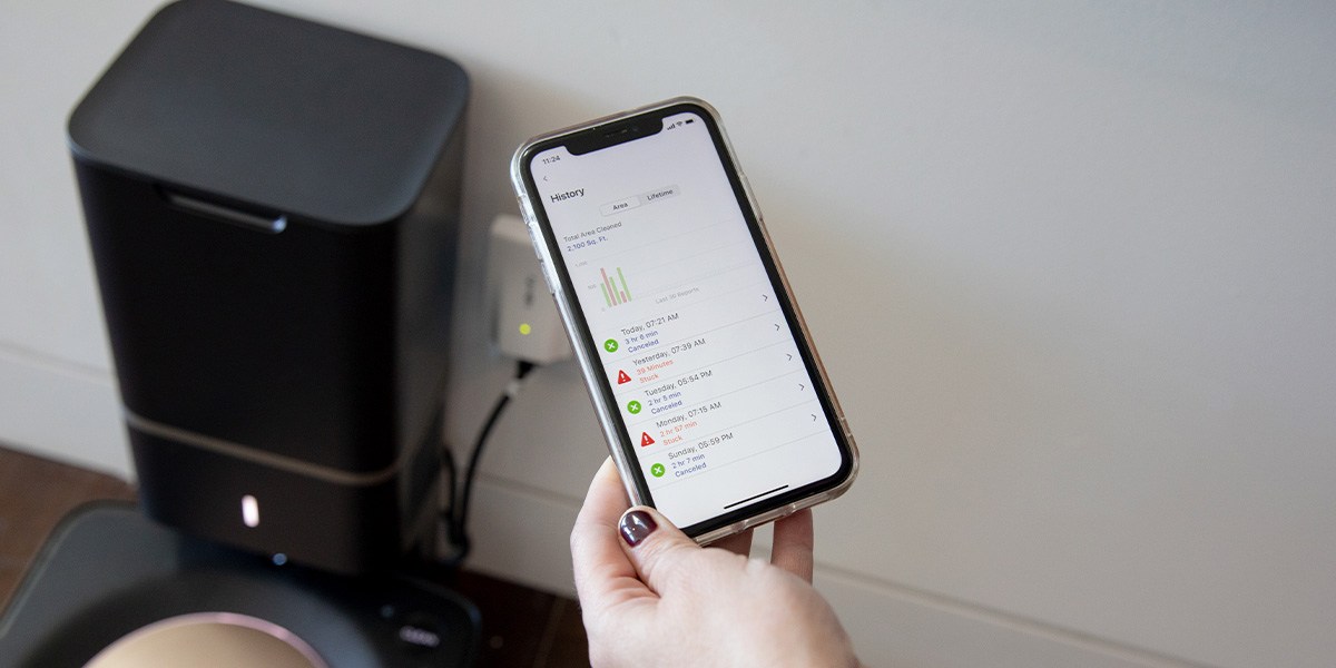 Person using interface app to navigate robot vacuum