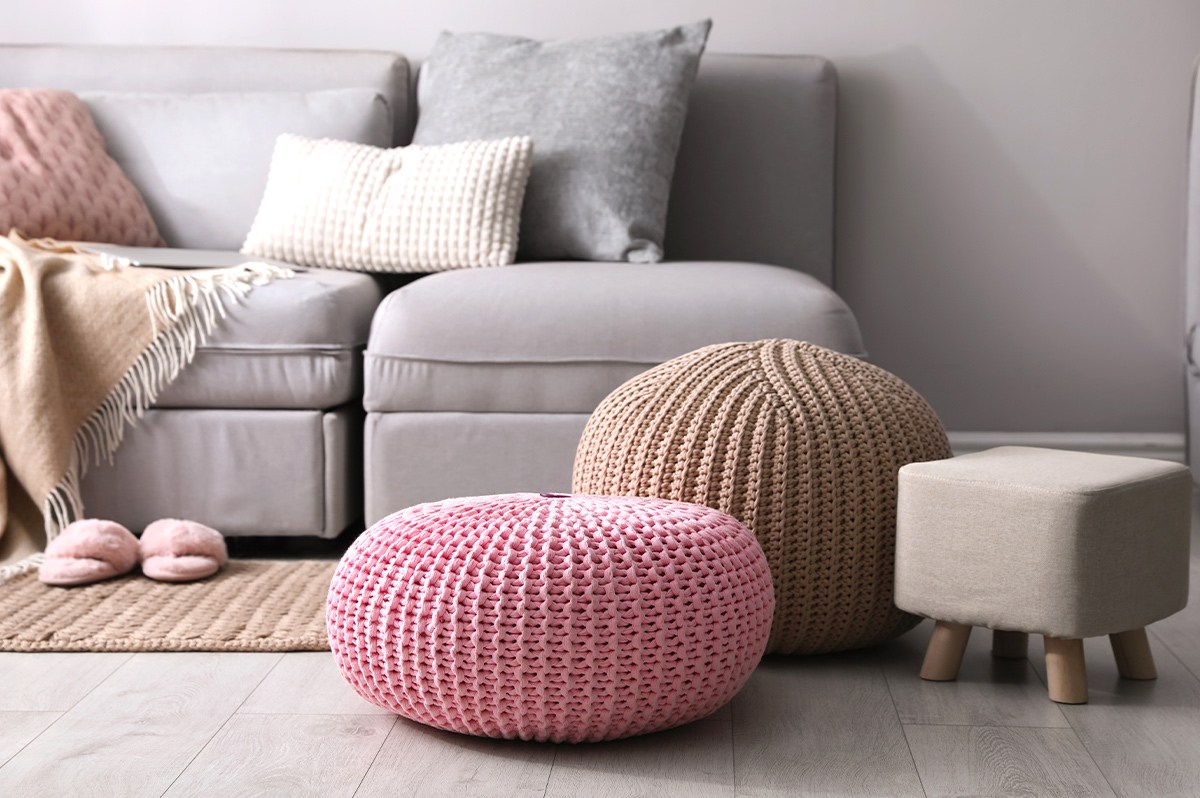 Three different foot rests next to a sofa