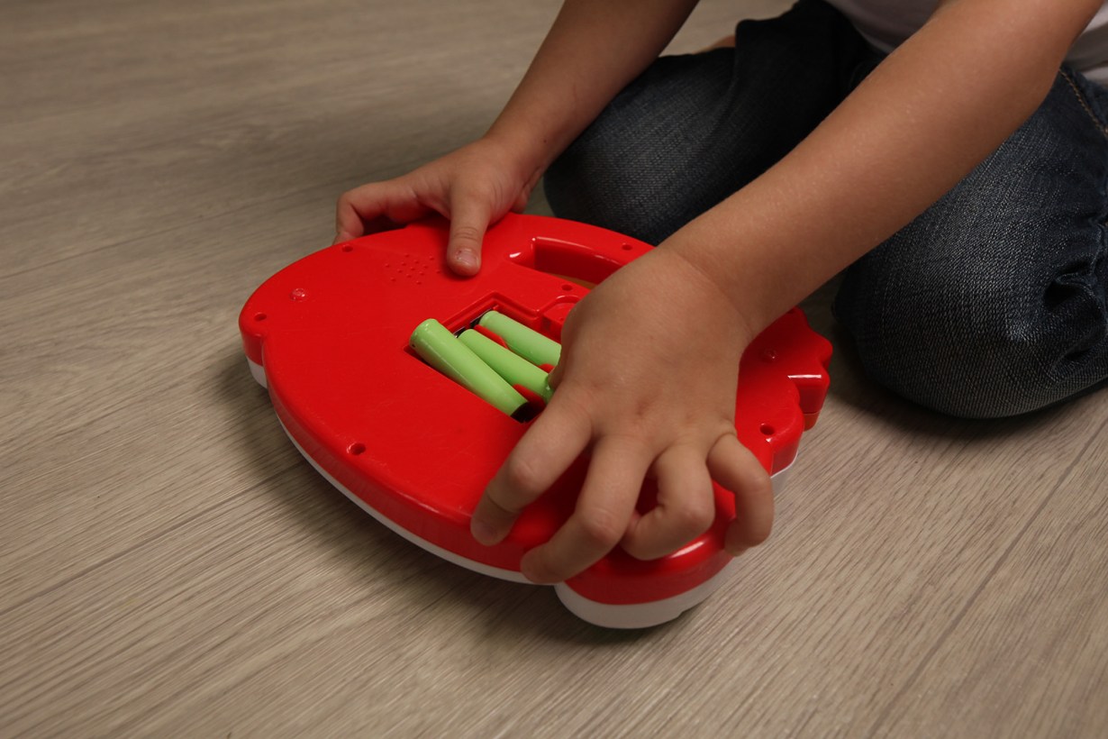 a child using batteries for toy