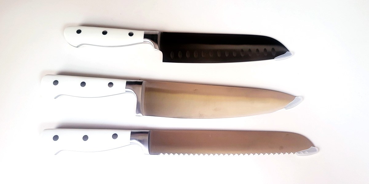 Three Carote 14-Piece Forged Knife Set knives displayed horizontally on kitchen counter